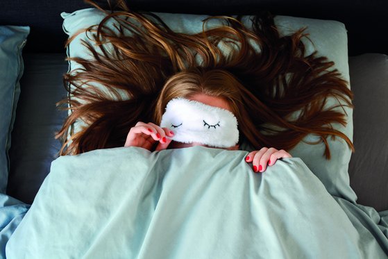 Frau mit Schlafmaske im Bett