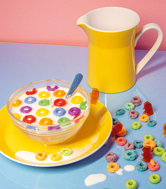 bunte Cerealien verteilt auf dem Tisch mit einem Krug Milch im Hintergrund