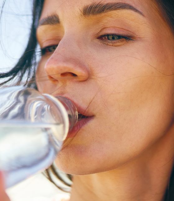 Frau trinkt aus einer Flasche