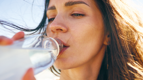 Frau trinkt aus einer Flasche