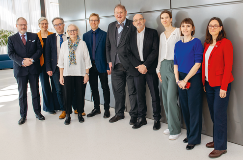 eine Gruppe Menschen steht vor einer Wand