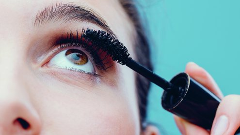 Frau tuscht sich die Wimpern