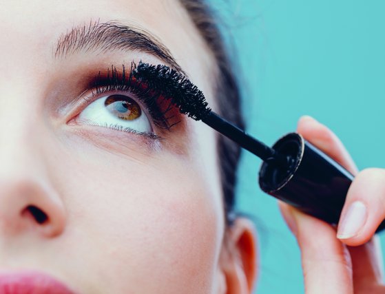 Frau tuscht sich die Wimpern