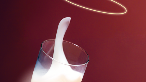 ein kippendes Glas Milch mit einem Heiligenschein