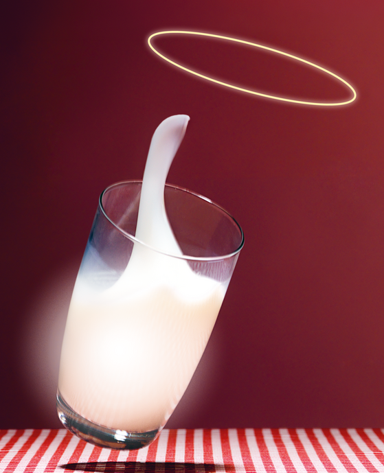 ein kippendes Glas Milch mit einem Heiligenschein