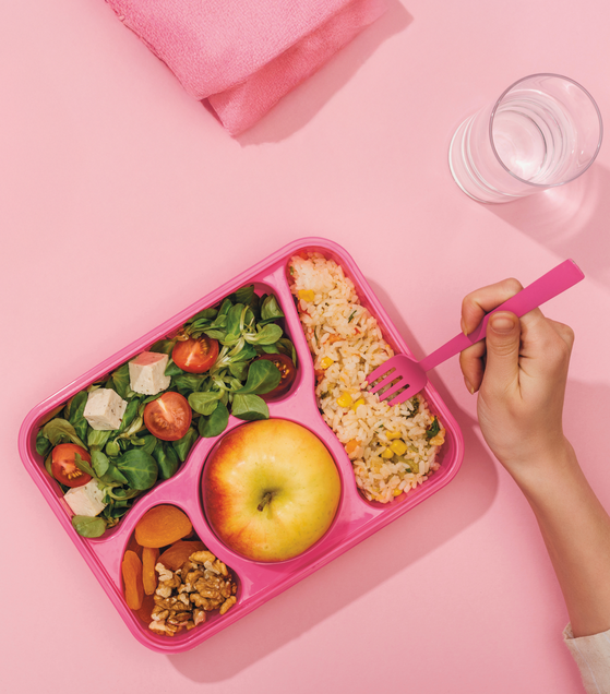 Aufbewahrungsbox mit Reis, Nüssen, Salat und Apfel